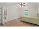 Comfortable bedroom with tray ceiling, hardwood floors, a queen bed, and natural light from a window at 3313 Henson Ln, Stockbridge, GA 30281