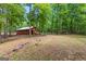 Charming exterior view of a cozy house nestled among mature trees and landscaping at 3313 Henson Ln, Stockbridge, GA 30281