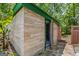 Unique exterior featuring wood-look siding and green trim, with an open door and surrounding greenery at 3313 Henson Ln, Stockbridge, GA 30281
