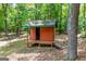 Quaint exterior view of a rustic orange colored outbuilding with a small porch and a bridge to the entrance at 3313 Henson Ln, Stockbridge, GA 30281
