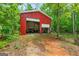 Exterior shot showcasing a garage building with open doors, surrounded by vibrant greenery at 3313 Henson Ln, Stockbridge, GA 30281