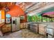 Rustic outdoor kitchen with stainless steel appliances, stone flooring, and wood accents, perfect for entertaining at 3313 Henson Ln, Stockbridge, GA 30281