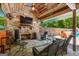 Covered outdoor living area with a stone fireplace, comfortable seating, and views of the pool and backyard at 3313 Henson Ln, Stockbridge, GA 30281