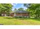 Exterior back view of a brick home with a wooden back deck, surrounded by a lush green lawn at 765 Shellnut Dr, Forest Park, GA 30297