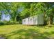 A metal storage shed situated in the expansive grassy backyard, partly shaded by mature trees at 765 Shellnut Dr, Forest Park, GA 30297