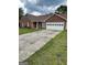A concrete driveway leads to a brick single-story home with an attached two-car garage at 201 Summerford Pl, Stockbridge, GA 30281