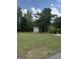 Spacious backyard with mature trees, a storage shed, and a well-maintained lawn at 411 Johnson Rd, Locust Grove, GA 30248
