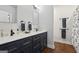 Bathroom featuring double sinks, storage cabinets, and a glass enclosed shower at 411 Johnson Rd, Locust Grove, GA 30248