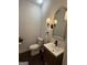 Stylish bathroom with a vanity, mirror, toilet, and elegant lighting fixtures at 411 Johnson Rd, Locust Grove, GA 30248