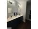 A bathroom features dual sinks with dark wood cabinets and modern light fixtures at 411 Johnson Rd, Locust Grove, GA 30248