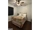 A simple bedroom featuring a bed with metal frame, ceiling fan and a window with blinds at 411 Johnson Rd, Locust Grove, GA 30248