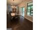 Bright dining room featuring a chandelier, sliding glass doors to a covered patio and hardwood floors at 411 Johnson Rd, Locust Grove, GA 30248