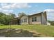 Back of house featuring a screened in porch, siding, green lawn, and cloudy sky at 411 Johnson Rd, Locust Grove, GA 30248