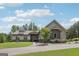 Beautiful exterior elevation featuring stone accents, gray siding, a well-manicured lawn, and a circular driveway at 411 Johnson Rd, Locust Grove, GA 30248