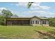 Back of house featuring a screened in porch, siding, green lawn, and cloudy sky at 411 Johnson Rd, Locust Grove, GA 30248