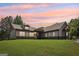 Charming home with stone accents, well-manicured lawn, and a beautiful sunset backdrop at 411 Johnson Rd, Locust Grove, GA 30248