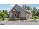 This angle showcases the gray exterior siding, stone accents, landscaping, and attached garage at 411 Johnson Rd, Locust Grove, GA 30248