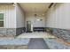 Covered front porch with decorative stone accents, a hanging lantern, and a comfortable bench at 411 Johnson Rd, Locust Grove, GA 30248