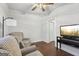 Relaxing living room featuring hardwood floors, two armchairs, TV and ceiling fan at 411 Johnson Rd, Locust Grove, GA 30248