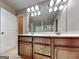 Bathroom with stained vanity, double sinks, and framed mirror at 330 Bentleigh Station Dr, Acworth, GA 30101