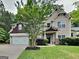 Inviting home featuring a lush green lawn, mature trees, and a two-car garage at 330 Bentleigh Station Dr, Acworth, GA 30101
