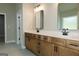 Bathroom with wood vanity, double sinks, quartz counters, black faucets, and black framed mirrors at 214 Wet Wood Ct # 26, Fairburn, GA 30213
