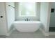 Soaking tub next to frameless shower in a bright bathroom with large light-filled window at 214 Wet Wood Ct # 26, Fairburn, GA 30213