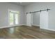 Bright bedroom with a sliding barn door and a glass patio door to a balcony at 214 Wet Wood Ct # 26, Fairburn, GA 30213