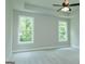 Spacious bedroom featuring neutral carpeting, a ceiling fan, and two large windows at 214 Wet Wood Ct # 26, Fairburn, GA 30213