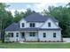 Two-story home with a stone facade, white siding, gray shutters, and well-manicured landscaping at 214 Wet Wood Ct # 26, Fairburn, GA 30213
