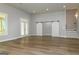 Open-concept living room with wood floors, recessed lighting, sliding barn door and staircase at 214 Wet Wood Ct # 26, Fairburn, GA 30213