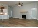 Open-concept living room with stone fireplace, seamlessly flowing into kitchen at 214 Wet Wood Ct # 26, Fairburn, GA 30213