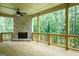 Back porch with a stone fireplace and an outdoor ceiling fan, overlooking a lush green forest at 214 Wet Wood Ct # 26, Fairburn, GA 30213