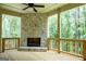 Covered deck with a stone fireplace, offering serene views of the surrounding trees at 214 Wet Wood Ct # 26, Fairburn, GA 30213