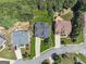Aerial view of homes with manicured lawns and mature trees in a quiet neighborhood at 2390 Colchester Ct, Cumming, GA 30041