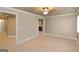 Carpeted basement featuring neutral walls, white trim, and an open doorway to another area of the basement at 2390 Colchester Ct, Cumming, GA 30041