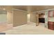 Open basement area with tile and carpet flooring, accented by white trim and a glimpse of the home theater at 2390 Colchester Ct, Cumming, GA 30041