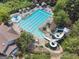 Aerial view of a resort-style community pool with waterslides, shaded seating, and lush landscaping at 2390 Colchester Ct, Cumming, GA 30041