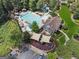Aerial view of a community pool area with waterslides, shaded seating, and mature landscaping at 2390 Colchester Ct, Cumming, GA 30041