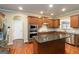 Modern kitchen with dark wood cabinets, stainless steel appliances, a central island, and hardwood floors at 2390 Colchester Ct, Cumming, GA 30041