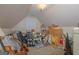 View of cluttered attic with a variety of items, sloped ceilings, and one window at 30 Joe Lee Dr, Sharpsburg, GA 30277