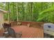Outdoor deck with wood flooring and railings, surrounded by lush green trees at 30 Joe Lee Dr, Sharpsburg, GA 30277