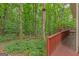 Backyard view with a lush green forest, a wooden path and a cozy deck at 30 Joe Lee Dr, Sharpsburg, GA 30277