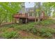 Back of house with raised deck, lush back yard, and a wooded view at 30 Joe Lee Dr, Sharpsburg, GA 30277
