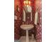 Small, colorful bathroom features a pedestal sink, patterned wallpaper, decorative lights, and mirror at 30 Joe Lee Dr, Sharpsburg, GA 30277