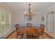 Bright dining room features a large window, chandelier, and rug beneath a wooden table with chairs at 30 Joe Lee Dr, Sharpsburg, GA 30277
