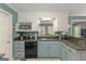 Kitchen with stainless dishwasher and microwave, featuring blue-grey lower cabinetry at 30 Joe Lee Dr, Sharpsburg, GA 30277