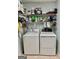 Well-equipped laundry room featuring a washer and dryer set with overhead shelving for supplies at 30 Joe Lee Dr, Sharpsburg, GA 30277