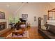 Bright living room featuring a fireplace, piano, and hardwood floors at 30 Joe Lee Dr, Sharpsburg, GA 30277