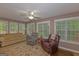 Cozy living room featuring plush seating, a ceiling fan, and large windows for natural light at 30 Joe Lee Dr, Sharpsburg, GA 30277